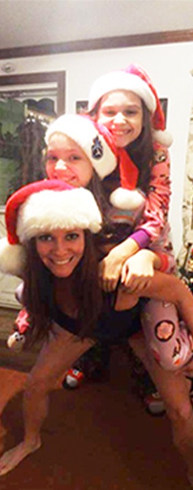 Photo of Desiree smiling while playfully giving a piggyback ride to her two daughters, showcasing her strength, which was highlighted by a physique coach from Stricker Elite Performance Systems in San Diego, CA.